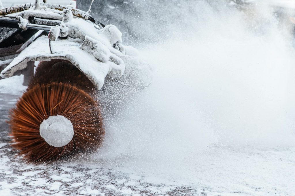 Snow plow does removal after blizzard in winter. Snow blower in motorway