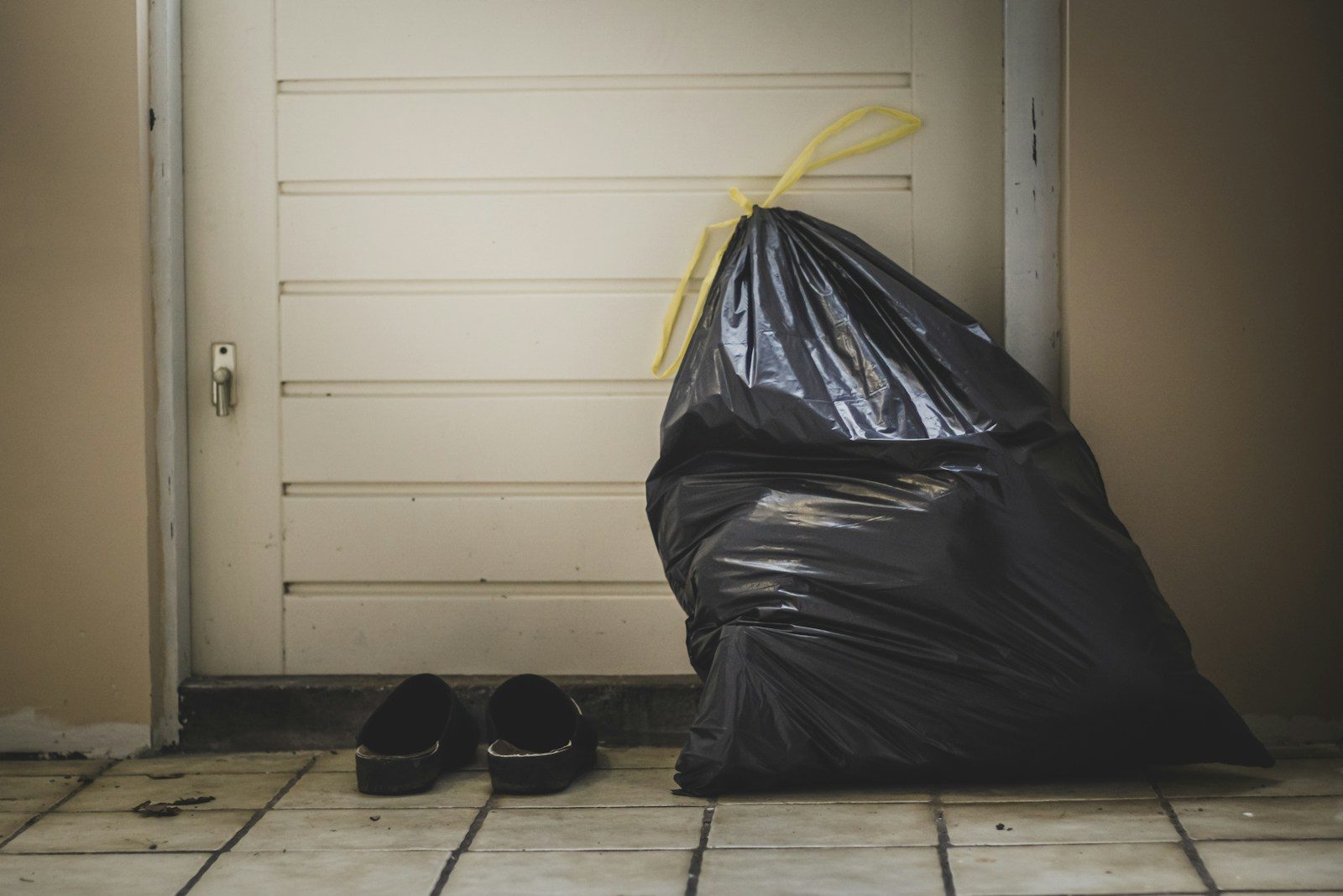 black plastic bag beside white wall
